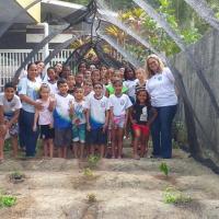 Diretora da Seccional Manaus com as crianças da CAE durante atividade do Dia da Árvore